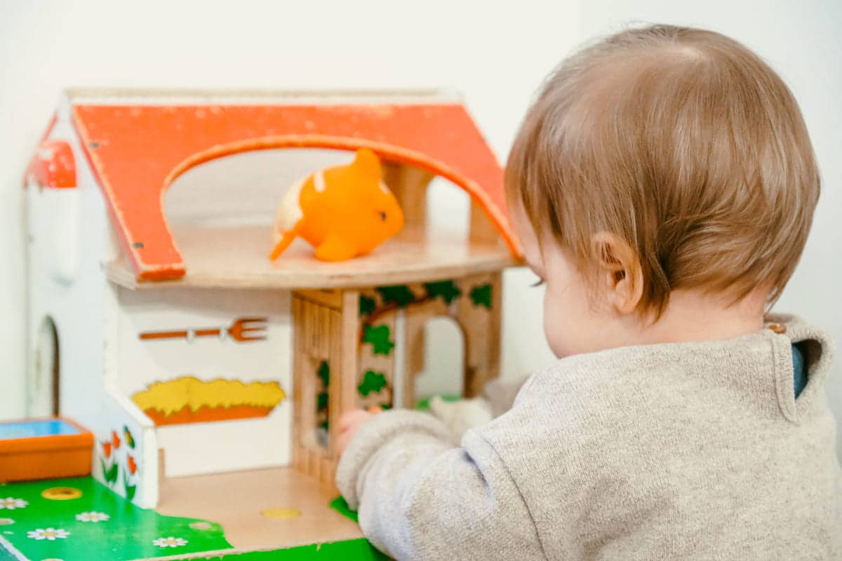 Photo d'un enfant qui joue avec une maisonnette en bois