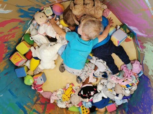 Photo d'un enfant qui dort entouré de peluche éco-responsable